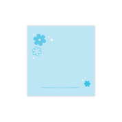 Pinkie Skies Studio Bloom Sticky Notes in pastel colors, featuring floral designs and a stack of notes on a desk.